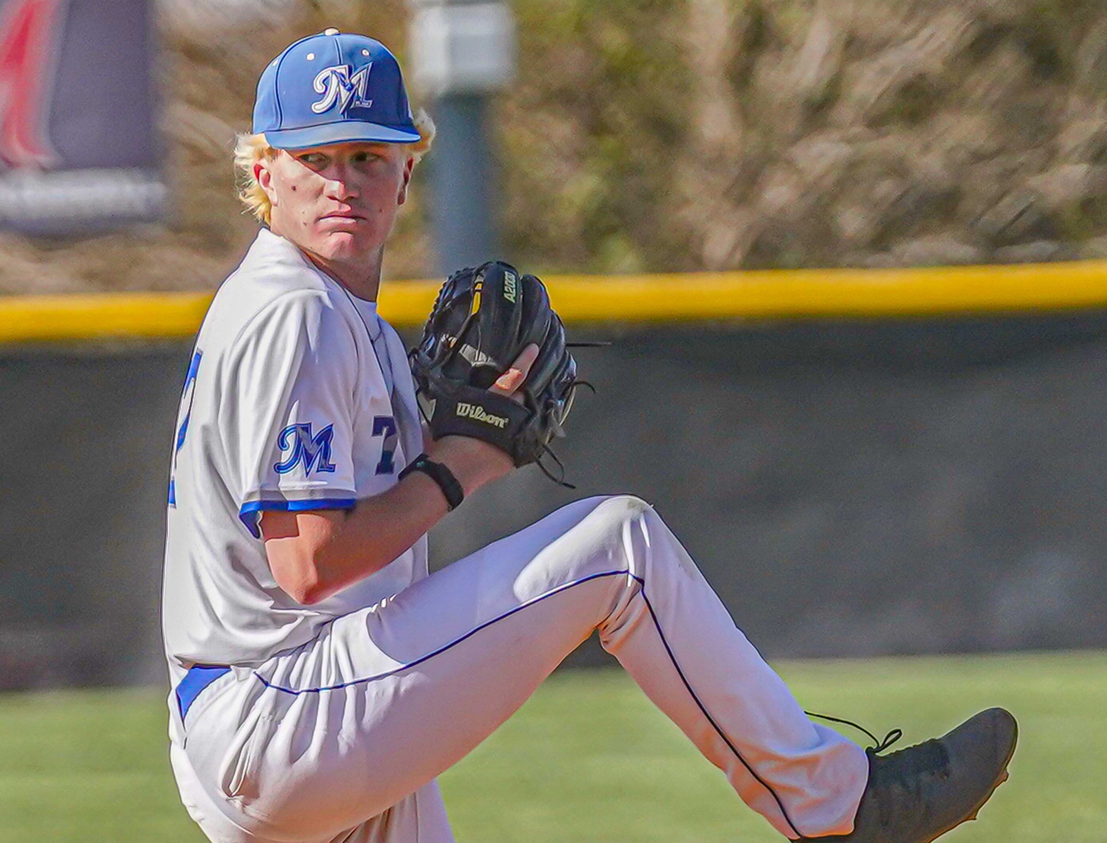 College baseball player throwing the ball.