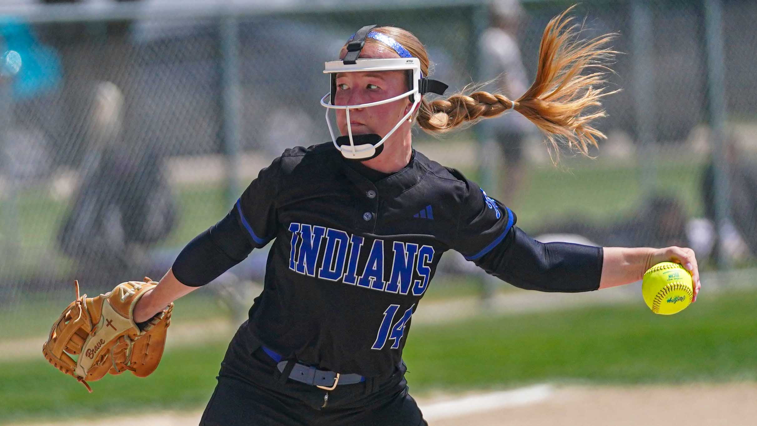 College softball player pitching the ball.