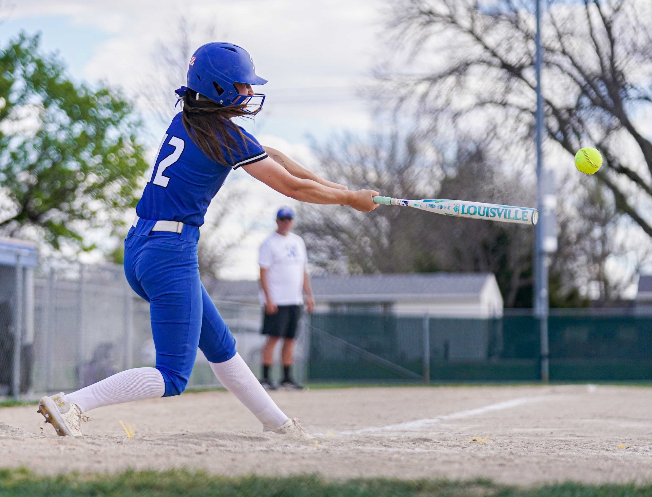 College softball player hitting the ball.