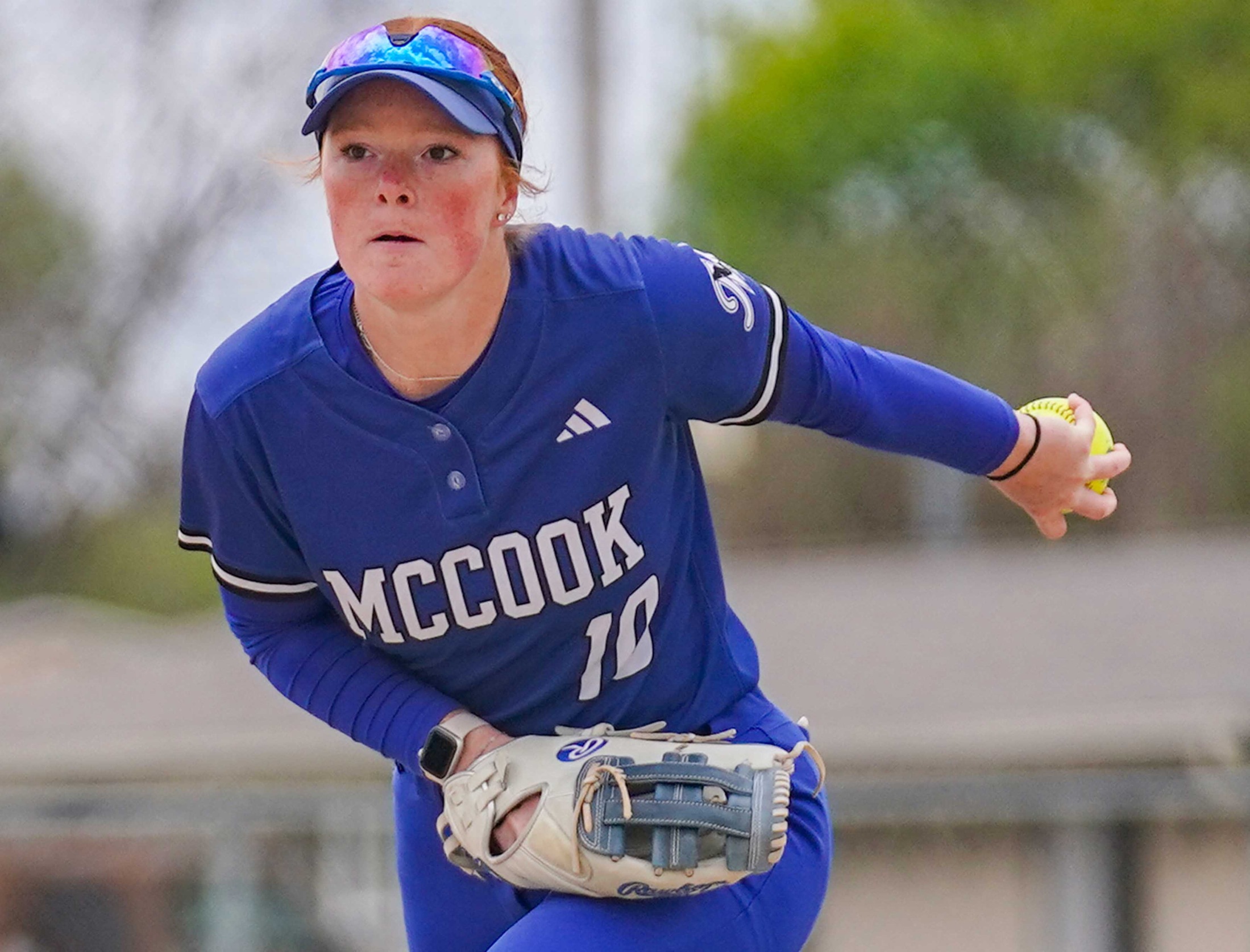 College softball player throwing the ball.