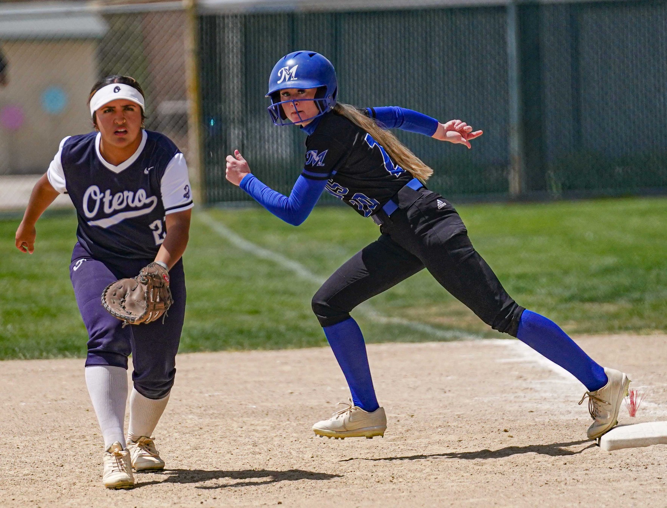 College softball player taking lead off first base.